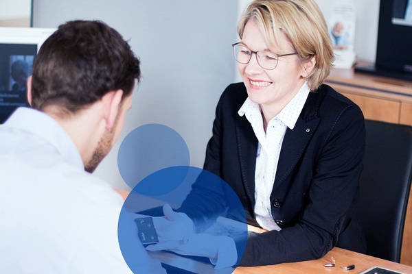 Zwei Personen führen ein Beratungsgespräch im modernen Büro einer Bank.